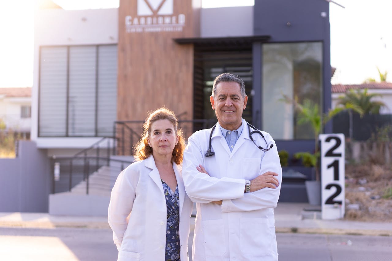 trusted-partner Man and woman doctors in lab coats standing confidently outside a modern medical facility.